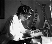 Artist Brenda Heim working on a calligraphy project sitting at her studio desk 